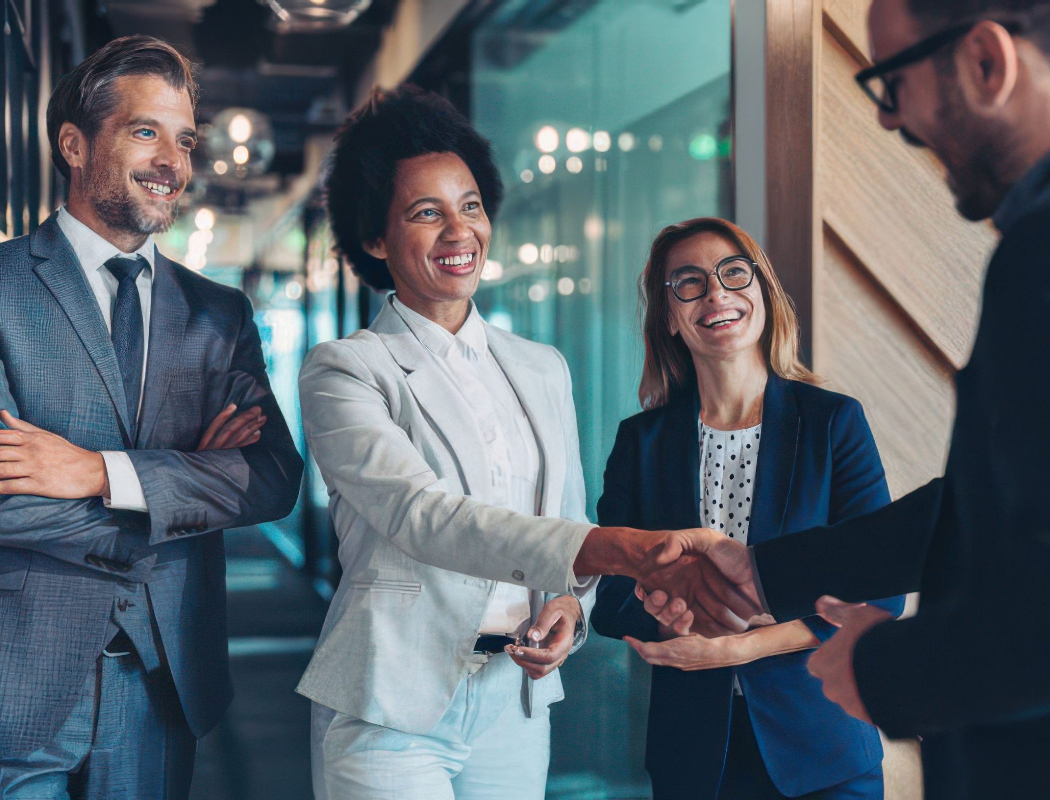 Group of business persons shaking hands in the office Group of business persons shaking hands in the office